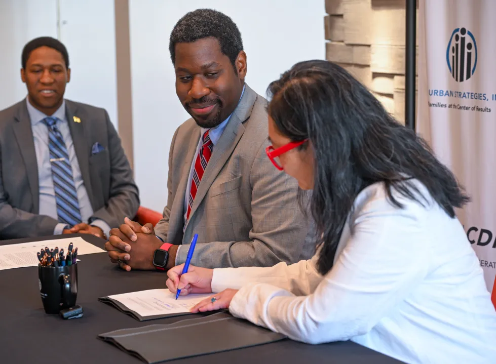 Eric Morrissette, Acting Under Secretary of Commerce for Minority Business Development, and Esther Shin, president of Urban Strategies Inc., sign a partnership agreement to support minority-owned businesses in Baltimore.